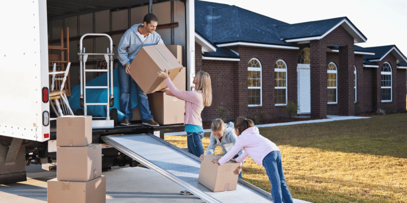 Family loading boxes into a moving truck while preparing for a move to Texarkana
