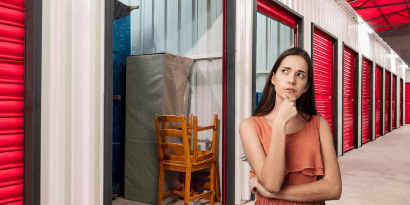 Woman choosing a self storage unit size inside a storage facility hallway