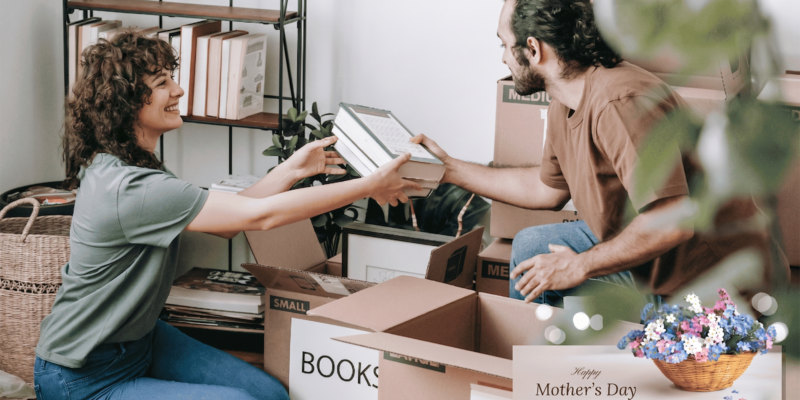 A couple organizing boxes and decluttering their home for Mother’s Day storage solutions